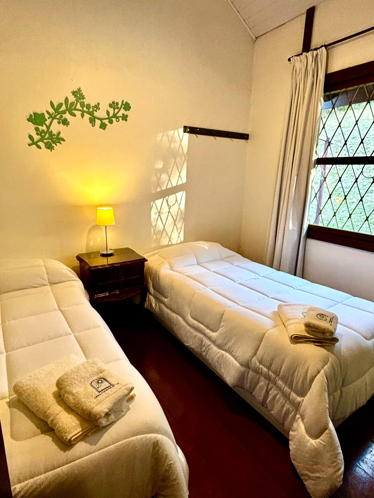 Quarto acolhedor com camas preparadas e toalhas